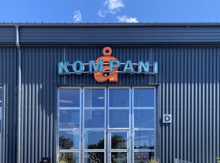 Fasad med stor neonskylt ÅKOMPANI