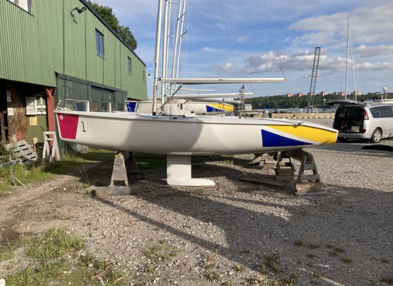 Segelbåt med färgytor i magenta, gul och blå