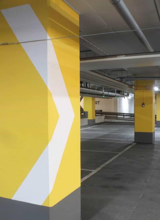 Parkeringsgarage med gul dekor på pelarna.