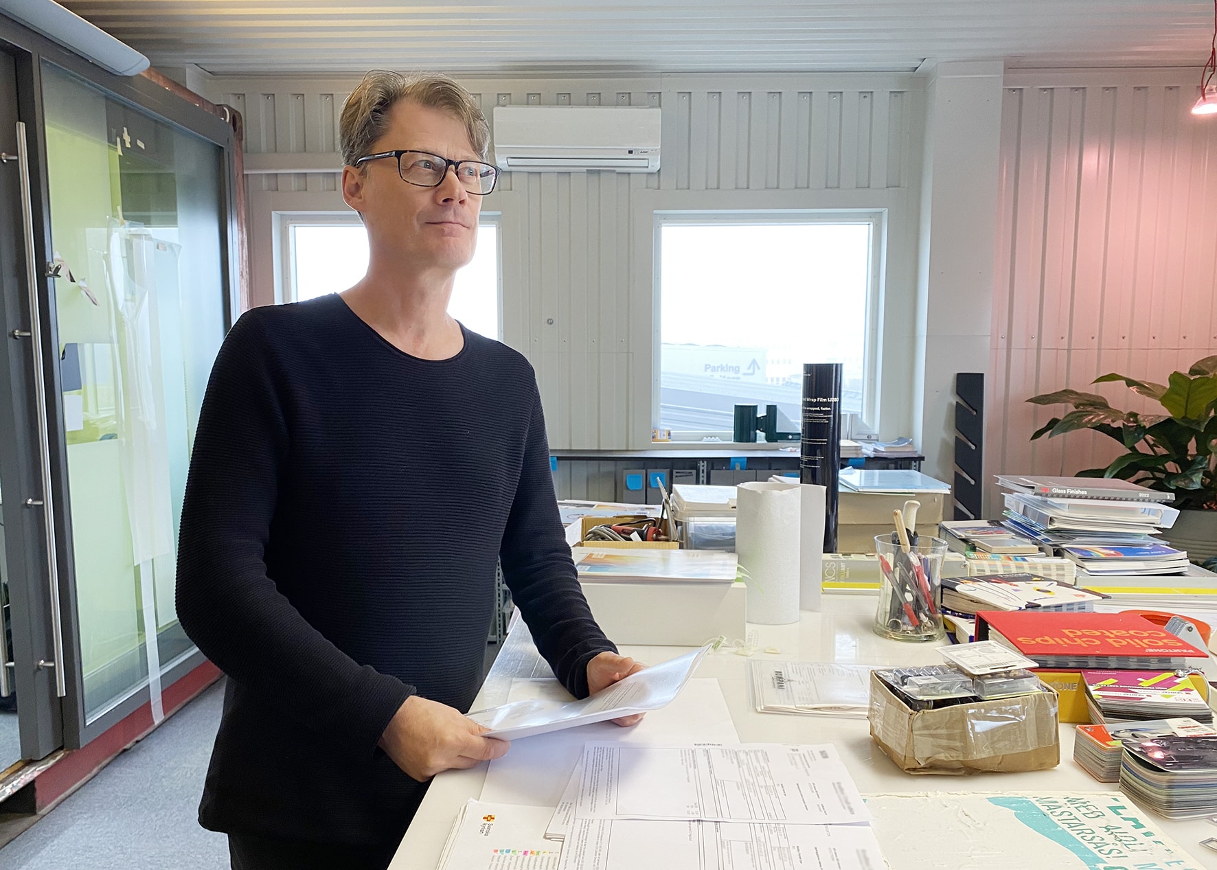 En man i mörkblå tröja står vid ett bord