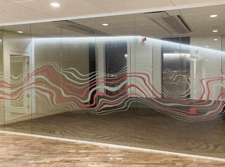 Glasvägg med mönster i röda och grå vågmönster
