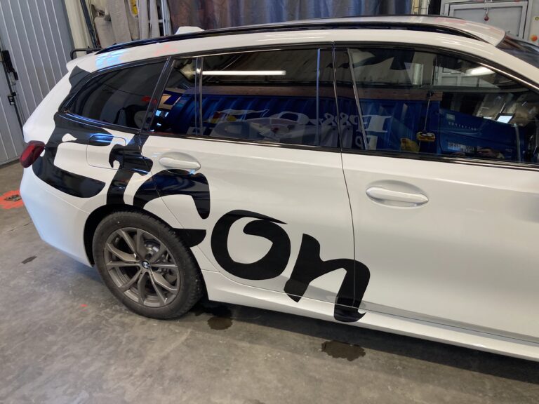 Vit bil med svart text: Etcon