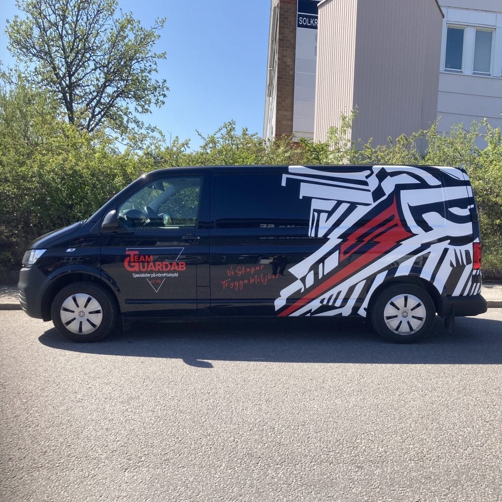 Svart transportbil med dekor i rött och vitt