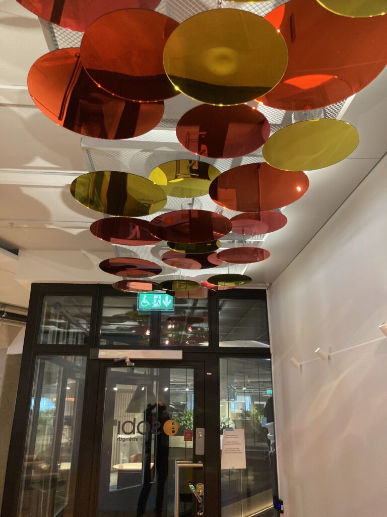 Takinstallation i orange, gul och rosa akrylskivor