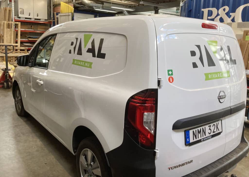 Vit skåpbil med text Rival