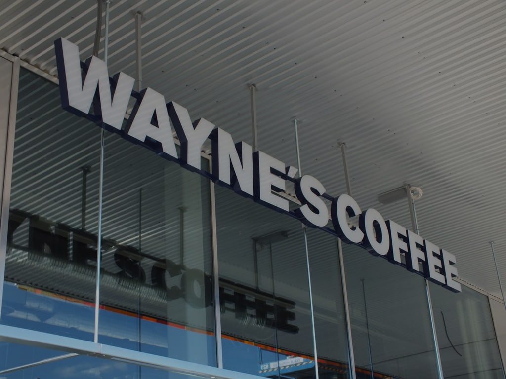 Mörklagd bild på Waynes coffees fasadskylt